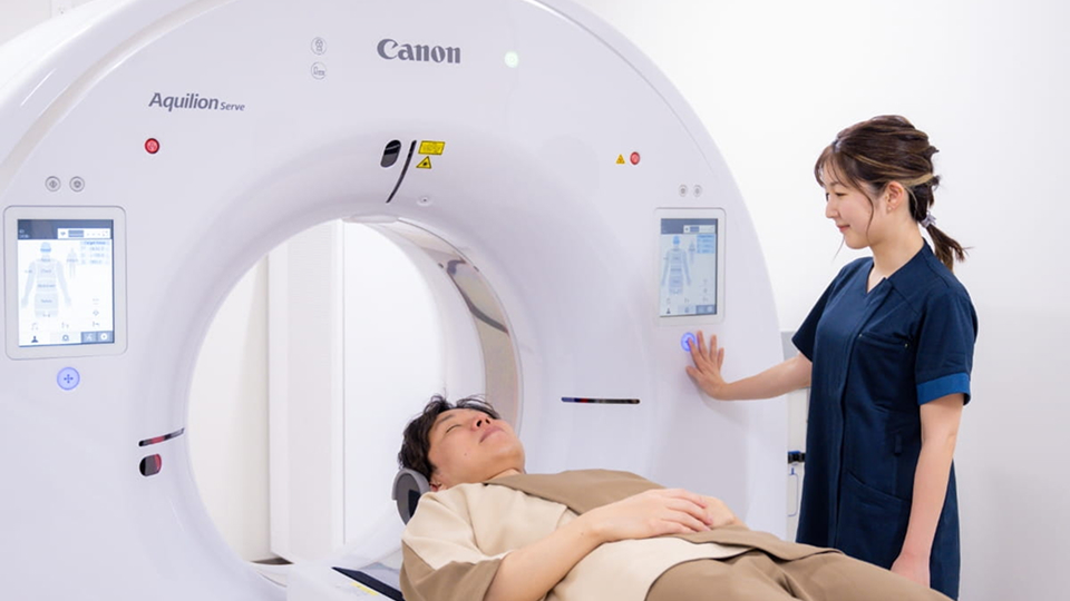 検査機器を操作する女性スタッフと検査を受ける男性