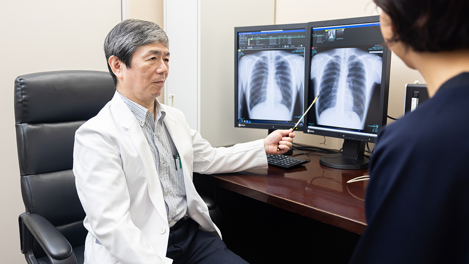 女性技師が女性受診者に検査内容を説明している様子